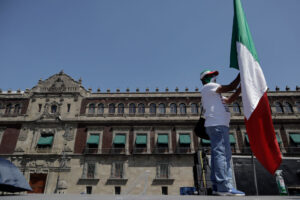 A man holds a Mexican flag in the city center. The country's opposition has struggled to mount effective resistance to the government's policies.