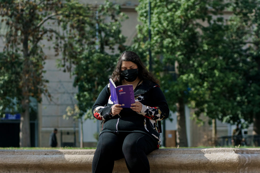 A woman reads a copy of the proposed Chilean constitution, as an up-or-down referendum on September 4 approaches.