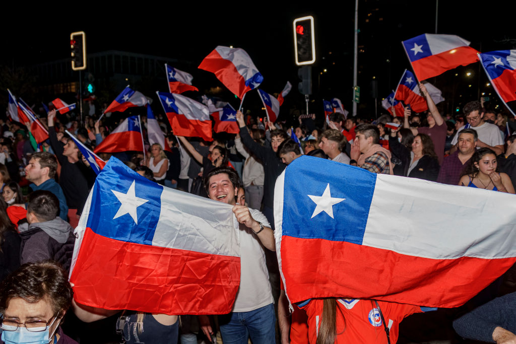 Chileans carrying flags celebrate Rechazo win in the plebiscite in Chile.