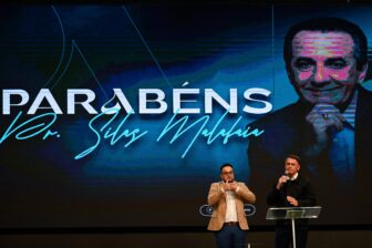 A Brazilian evangelical megachurch pastor and former President Jair Bolsonaro of Brazil stand together on stage.