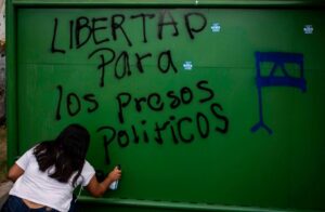 A university student in Managua, Nicaragua spraypaints a message demanding the release of Nicaragua's political prisoners.