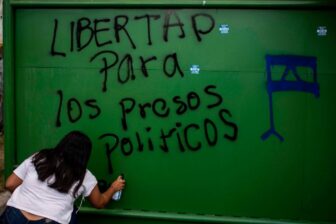 A university student in Managua, Nicaragua spraypaints a message demanding the release of Nicaragua's political prisoners.