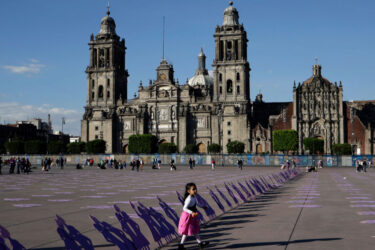A girl walks by silhouettes of wooden women placed in front of the Metropolitan Cathedral in Mexico City to mark the International Day for the Elimination of Violence against Women on Nov. 25, 2023. Gender-based violence Is at the center of Mexico’s security crisis, and a recent mob attack underscores the need to recognize the gendered dimensions of violence in a critical election year.