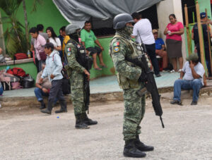 Soldiers help villagers at an emergency shelter on June 11 after violent conflict in southern Mexico.