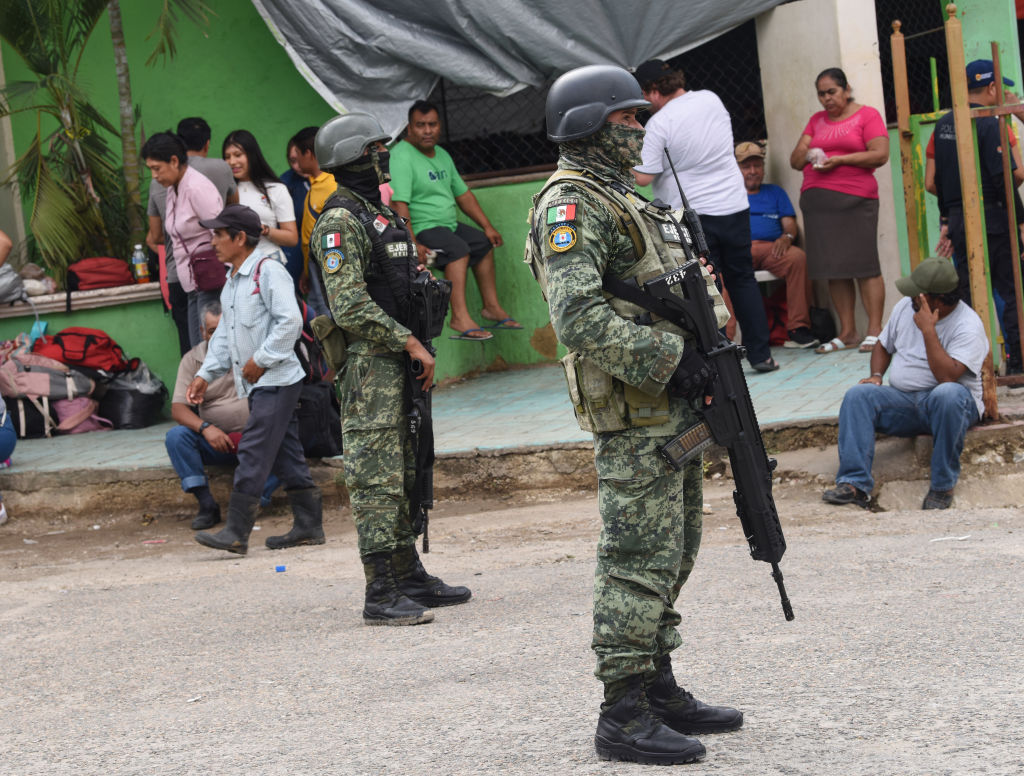 Soldiers help villagers at an emergency shelter on June 11 after violent conflict in southern Mexico.