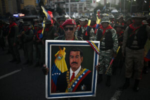 A member of the Bolivarian militia holds a picture of Nicolas Maduro during a military rally in Caracas on September 23, 2025.