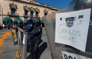 Police officers stand guard in Morelia, Michoacán state on Nov. 3 as protesters demonstrate against the assassination of Uruapan Mayor Carlos Manzo.