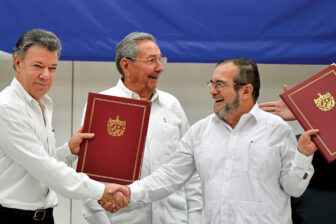 Colombia’s President Juan Manuel Santos (left) and Timoleón Jiménez, known as “Timochenko” (right), the FARC’s leader, shake hands in Cartagena in 2016 before the Peace Accord was finalized. Cuba’s President Raúl Castro (center) accompanied them.