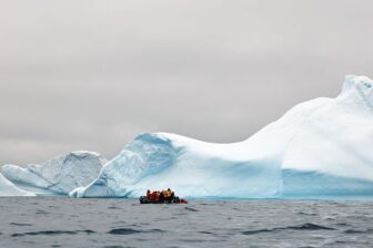 People take photos of an iceberg near the coast of Spert Island in Antarctica in December 2025.