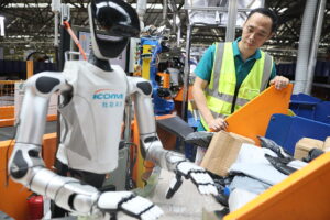 Postal workers monitor humanoid robots on the sorting line at the Guangzhou Mail Distribution Center in China’s Guangdong province in September.