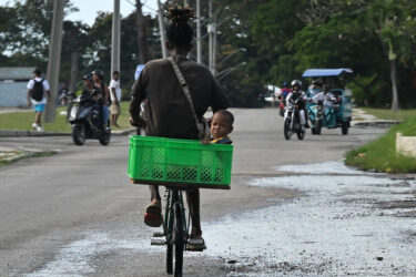 A man rides a bicycle with a boy in a basket during a blackout in Havana on September 18, 2026.